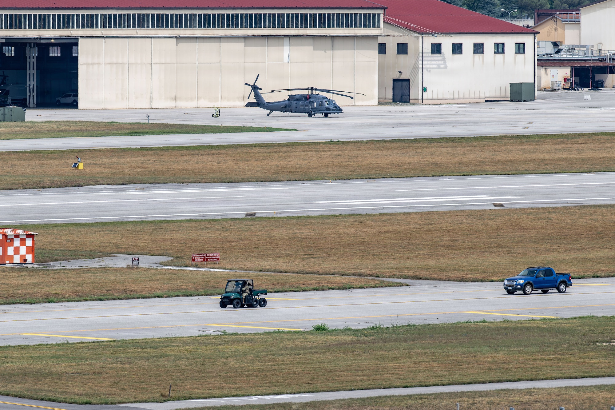 Two cars drive across a taxiway