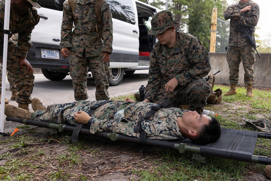 U.S. Navy Hospitalman Bryan Bishop, a corpsman with Combat Logistics Battalion 22, 2nd Marine Logistics Group, secures a simulated casualty onto a stretcher during a heat casualty drill as part of Command Post Exercise 2 at Marine Corps Outlying Landing Field Atlantic, North Carolina, Aug. 25, 2026. From 17-28 Aug, the 26th MEU conducted CPX 2 to enable joint, all-domain command and control by validating its systems architecture, refining key battle drills, and developing baseline templates and procedures to inform future operations. (U.S. Marine Corps photo by Cpl. Jesse Davis)