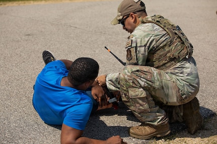 U.S. Air Force Tech. Sgt. Joel Ayala, assigned to the 103rd Security Forces Squadron, Connecticut Air National Guard, assists a role player during a simulated emergency response scenario at the Combined Arms Collective Training Facility at Fort McCoy, Wisconsin, Aug. 25, 2026.