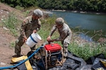 Spc. Jose Marfisi and Spc. Esteven Llopiz, assigned to the 714th Quartermaster Water Purification Company, secure a raw water intake pump during a Water Purification Rodeo at Lago Cerrillos, Ponce, Puerto Rico, July 24, 2026. The Soldiers positioned and secured the intake pump to ensure a continuous flow of raw water from the reservoir into the water purification system. The task is a critical step in establishing expeditionary water purification operations that provide safe, potable water in support of military operations and domestic emergency response missions. Photo by Sgt. 1st Class Eric Maldonado.