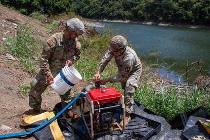 Spc. Jose Marfisi and Spc. Esteven Llopiz, assigned to the 714th Quartermaster Water Purification Company, secure a raw water intake pump during a Water Purification Rodeo at Lago Cerrillos, Ponce, Puerto Rico, July 24, 2026.