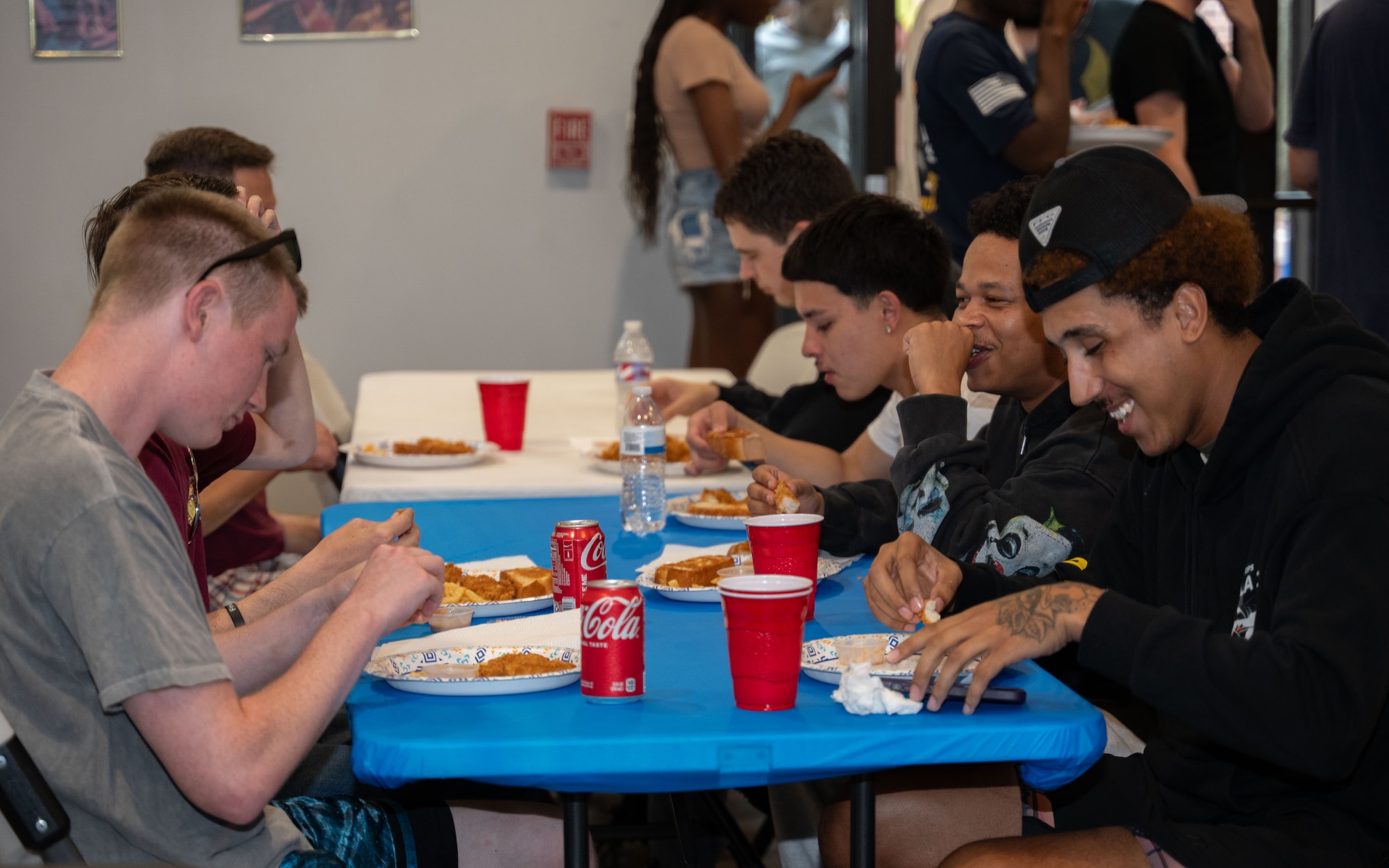 U.S. Air Force Airmen and civilians gather and eat at table