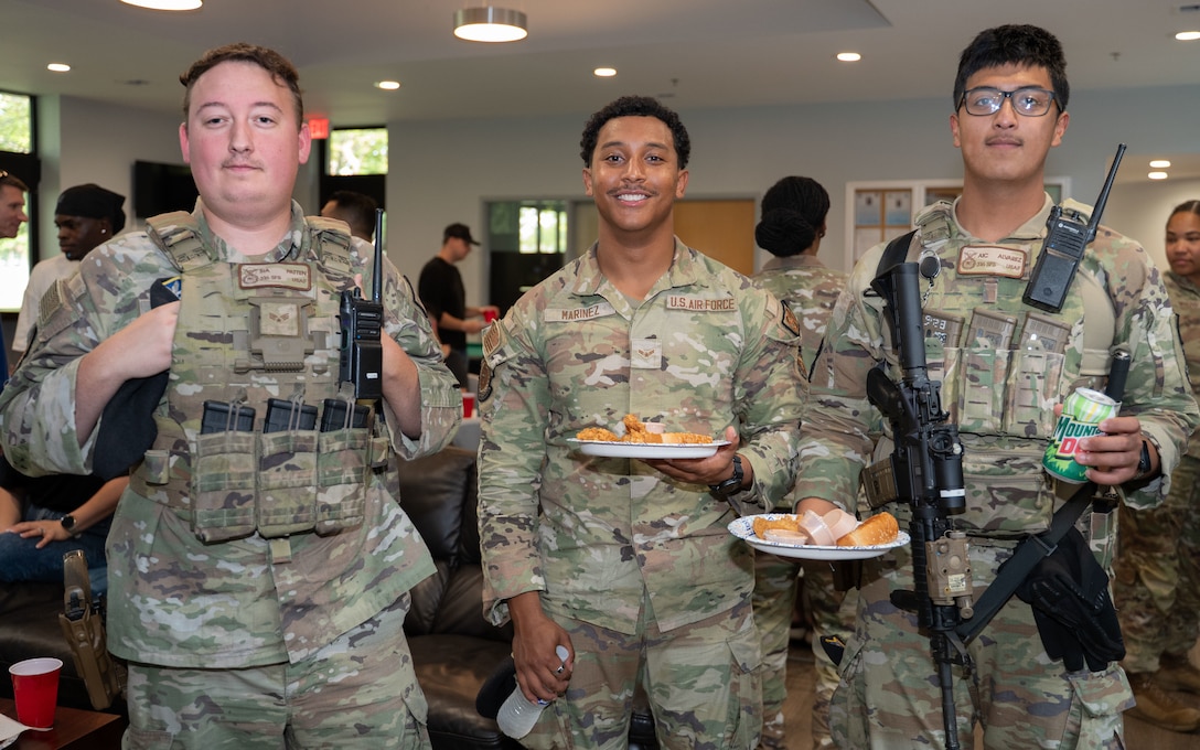 From left, U.S. Air Force Senior Airman Chase, Patten, Airman 1st Class Luis Marinez and Airman 1st Class Ramon Alvarez, all Security Forces Defenders assigned to the 316th Security Forces Squadron, attend a dorm dinner