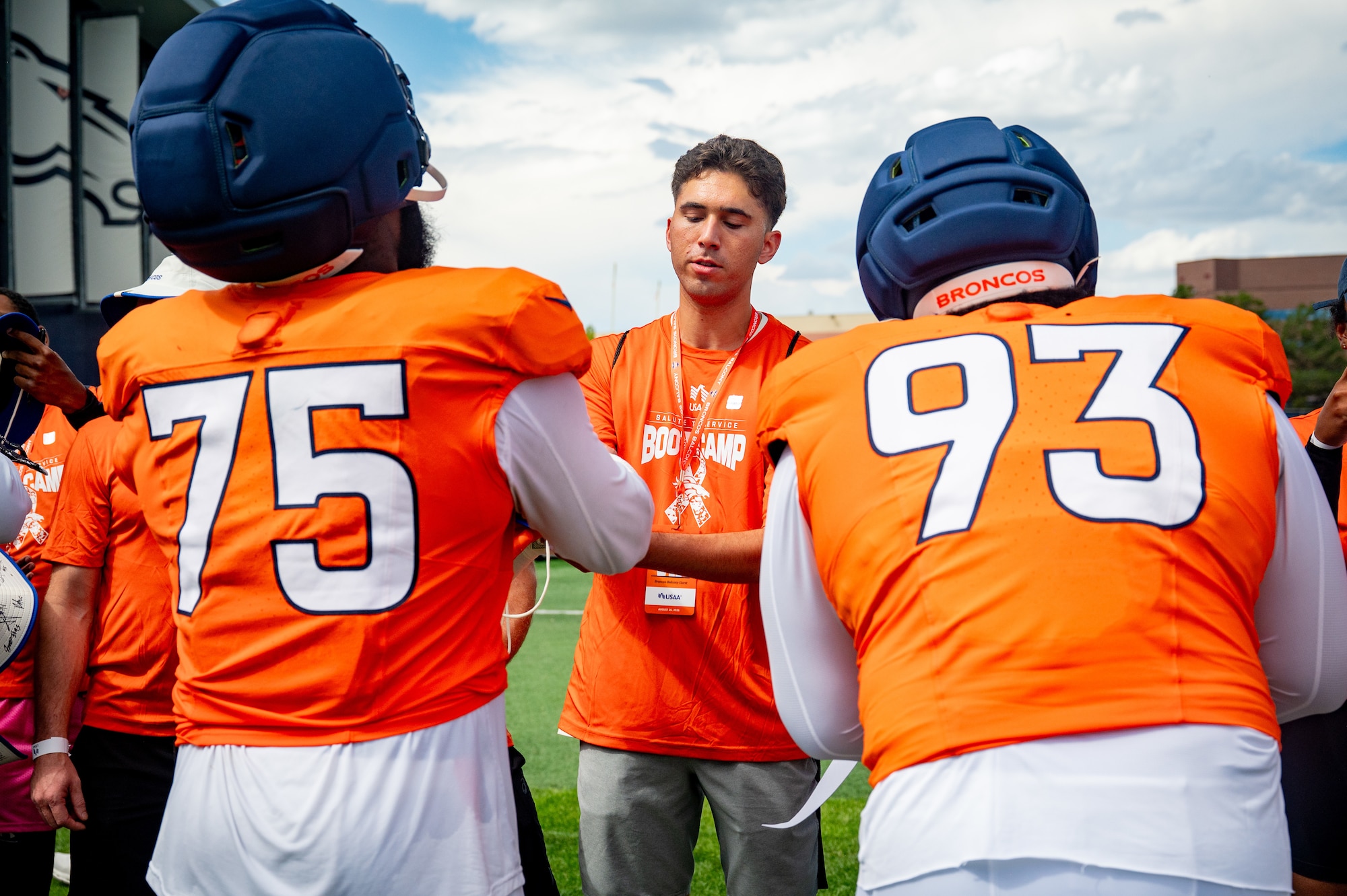 U.S. Air Force Airman 1st Class Jared Natisin, 561st Network Operations Squadron enterprise assessment operator, receives an autograph from Denver Broncos players