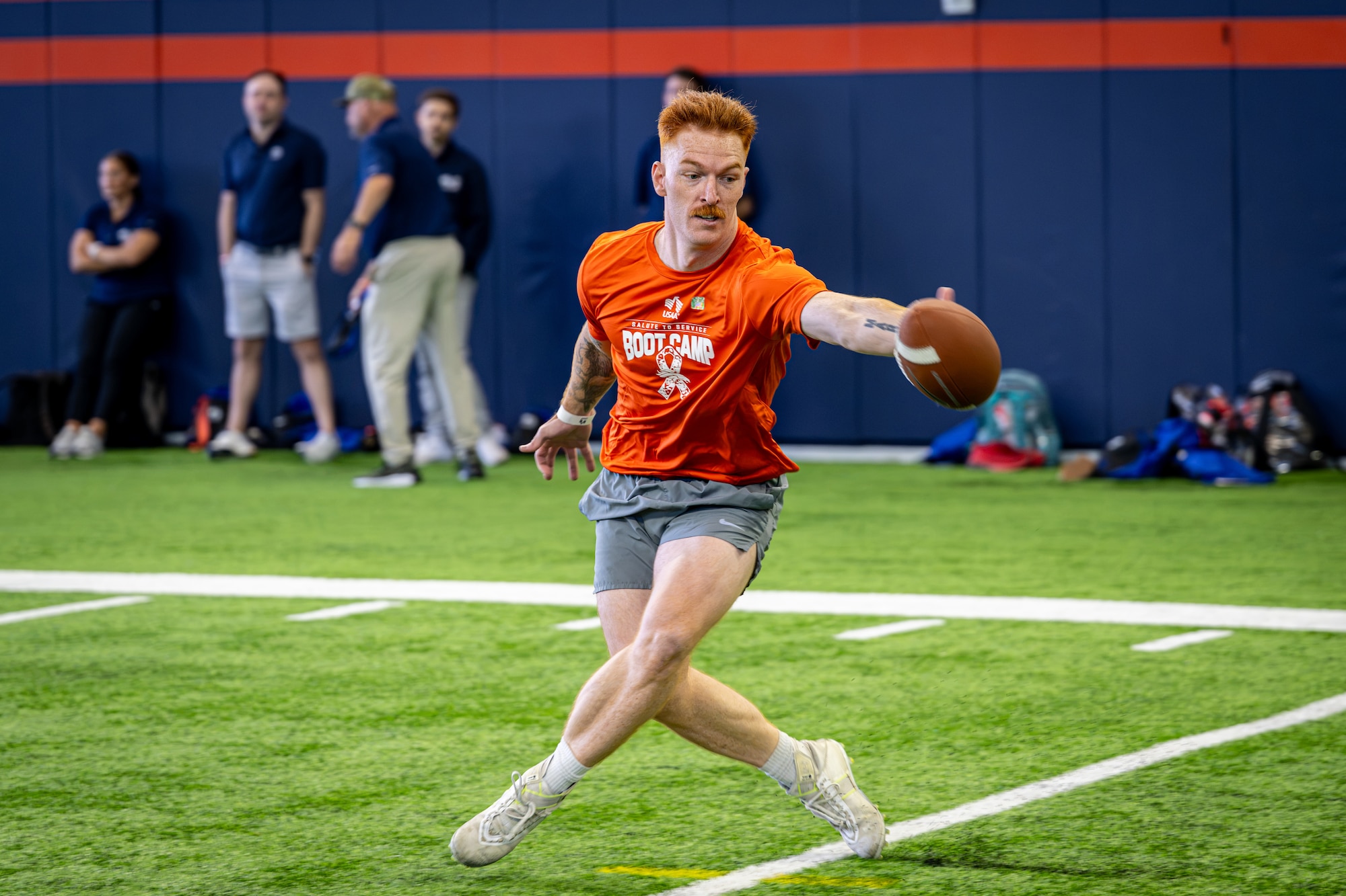 U.S. Space Force Tech. Sgt. Parker Martin, 62nd Cyber Squadron tactical developer, catches a football during the USAA Salute to Service Boot Camp