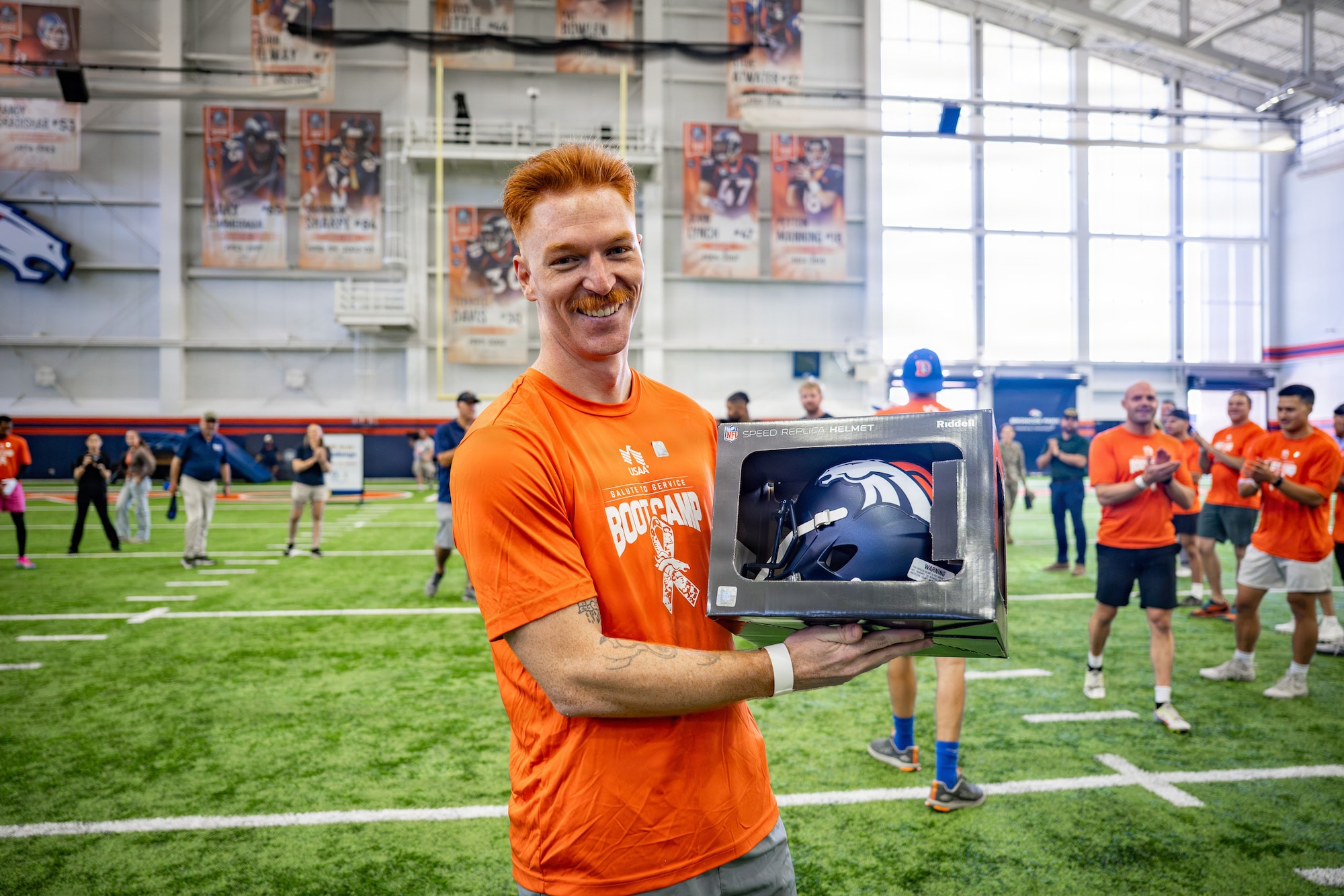 U.S. Space Force Tech. Sgt. Parker Martin, 62nd Cyber Squadron tactical developer, poses for a photo after receiving a signed Denver Broncos helmet for winning the quarterback arm challenge