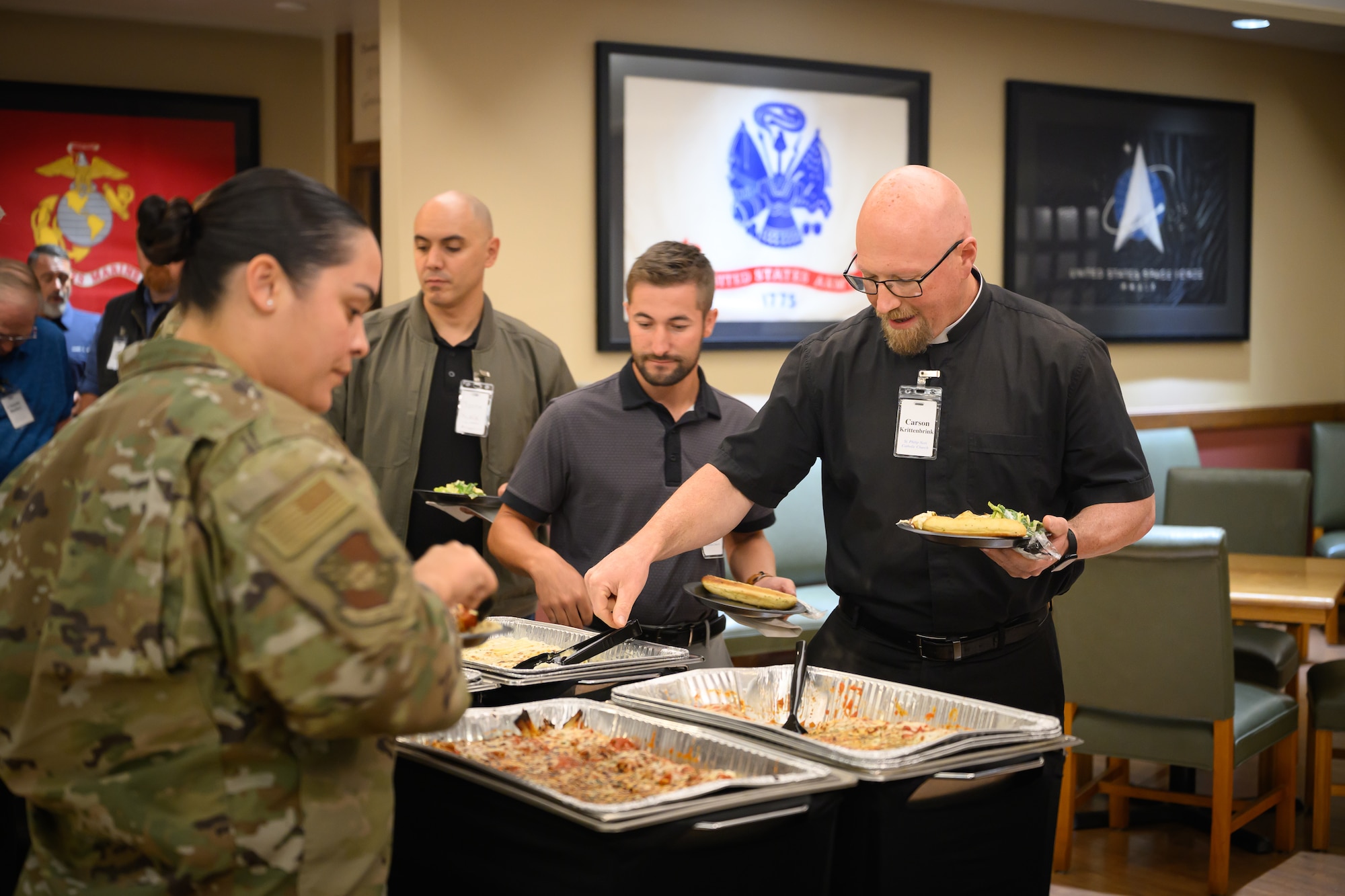 Uniformed and non-uniformed personnel gather at tables