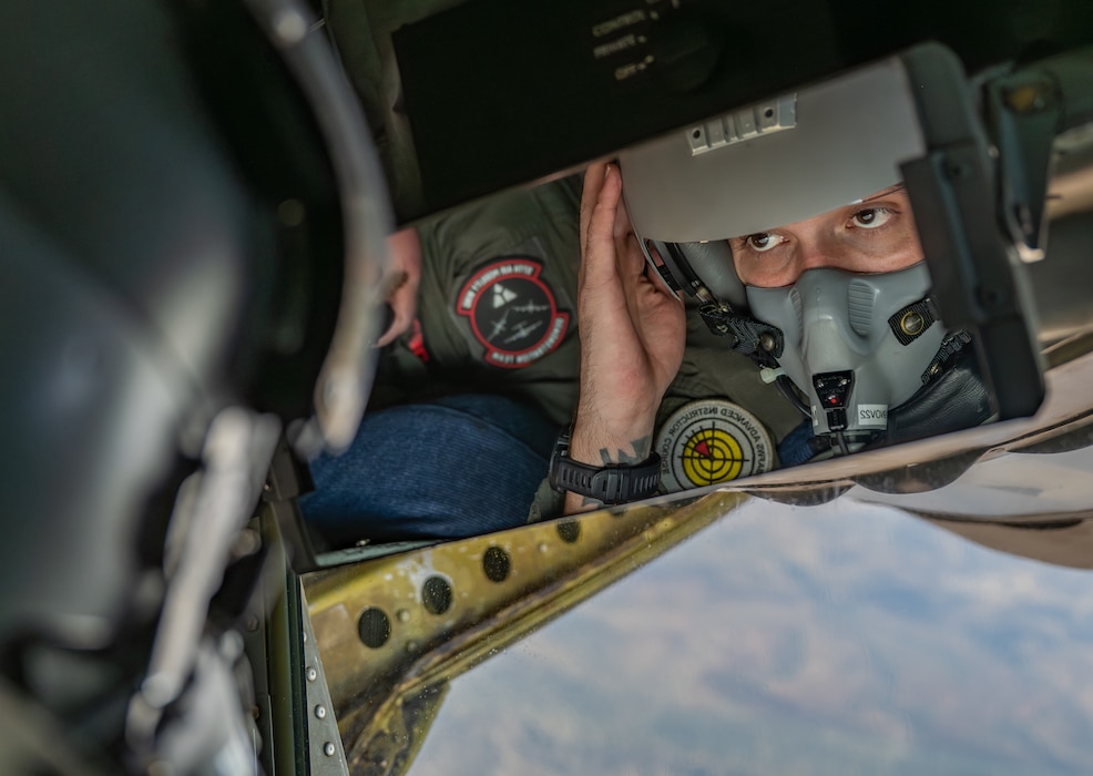 U.S. Air Force Master Sgt. Alex Esquibel, 54th Air Refueling Squadron KC-135 formal training unit evaluator boom operator, adjusts his flight helmet prior to in-flight refueling four U.S. Air National Guard F-16 Fighting Falcon aircraft above the east side of New Mexico, Aug. 20, 2026. Since the four F-16s received fuel from the KC-135 Stratotanker aircraft traveling to and from Airshow London 2026, they didn’t need to land during the trip. (U.S. Air Force photo by Airman 1st Class Emma Wright)