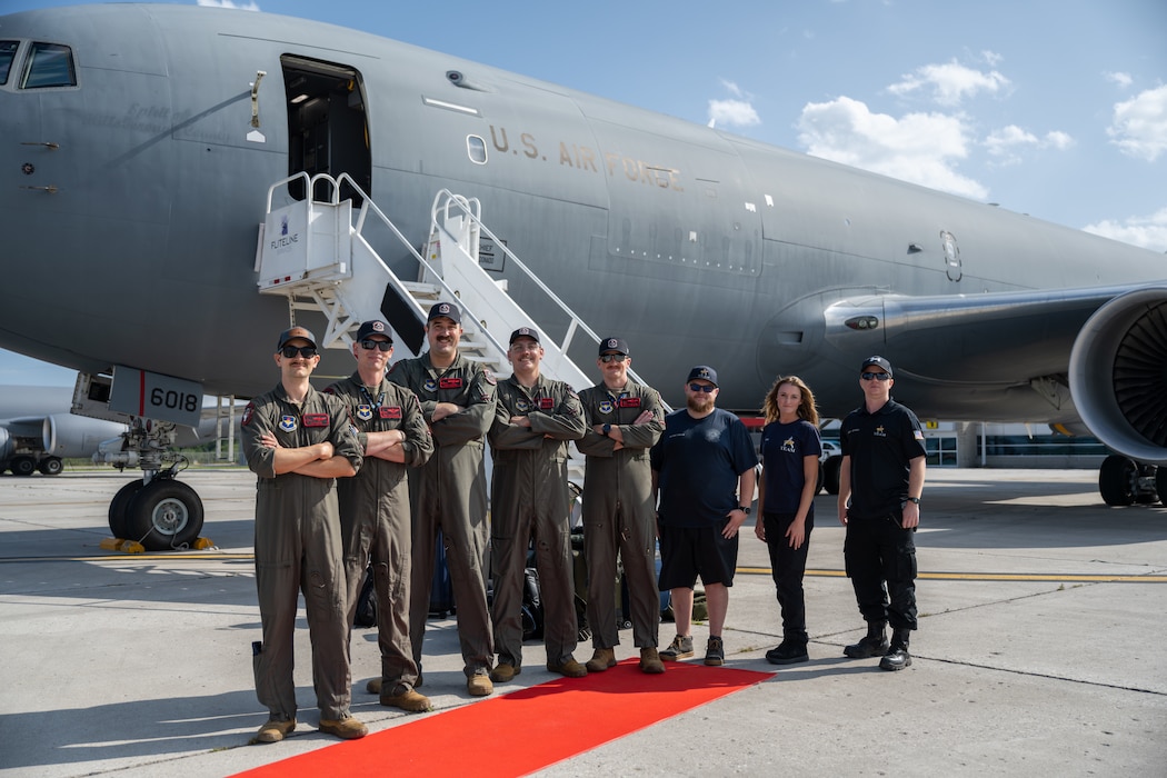 The Altus Air Force Base KC-46 Pegasus demonstration team smiles in front of the U.S. Air Force KC-46 Pegasus aircraft in London, Ontario, Aug. 20, 2026. The KC-46 is a modern aerial tanker that refuels military aircraft while in flight. (U.S. Air Force photo by Airman 1st Class Emma Wright)