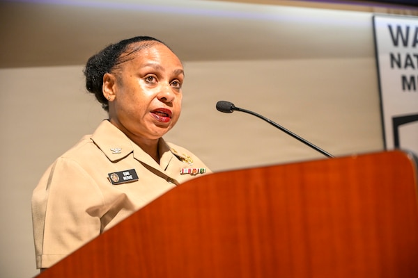 U.S. Navy Capt. Toni McCrae (Retired) speaks as the guest speaker at Senior Chief Hospital Corpsman Thomas Riggs retirement ceremony at Walter Reed National Military Medical Center, August 20, 2026. Navy Medicine Readiness and Training Command (NMRTC) Bethesda mission is to maximize warfighter performance through optimized medical readiness tailored to operational requirements; enhance the readiness of the medical force to sustain expeditionary medical capability; and train and develop the Navy Medicine Force. (U.S. Navy photo Mass Communication Specialist Second Class Alec Kramer)