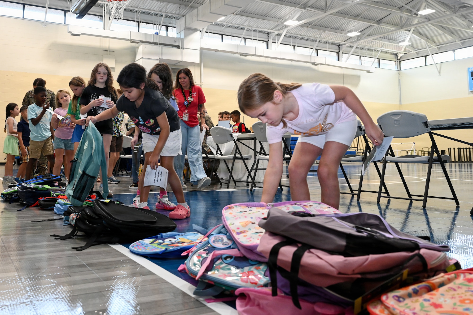 Military children grabbing a backpack for the upcoming school year.