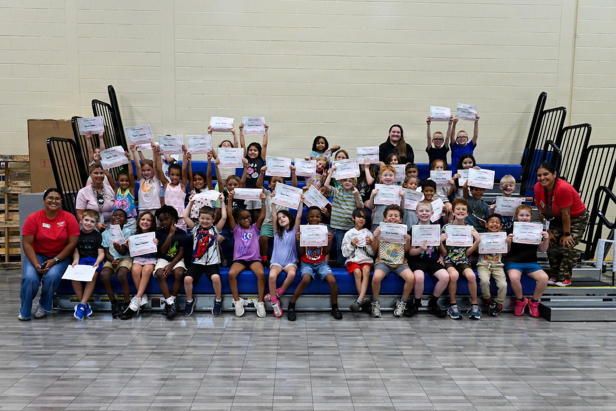 Military children displaying there diploma of mission completed.