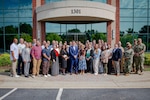 Staff and service members pose for a photo during the Navy Operational Medicine Information Technology & Fielding Summit in Chesapeake, Virginia, Aug. 24, 2026. The five-day summit, held at the CACI Building in Chesapeake, brings together senior leaders from BUMED, Fleet commands, Naval Information Warfare Centers, and Joint Operational Medicine Information Systems teams. The primary objective was to deliver agile, trained, and certified medical units to support the Fleet, Fleet Marine Force and expeditionary medical facilities. (U.S. Navy photo by Mass Communication Specialist 2nd Class Levi Decker)