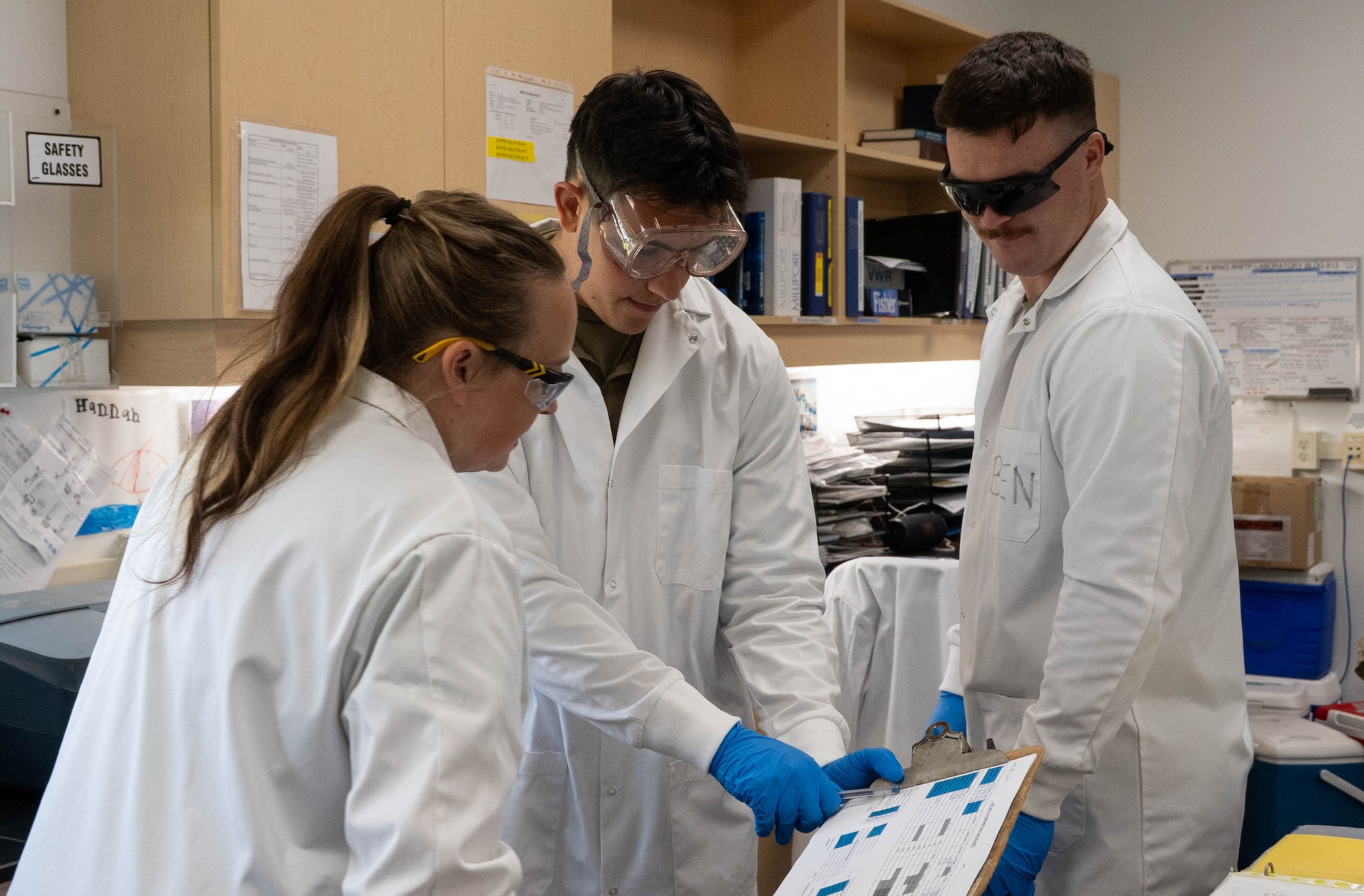 Airman 1st Class Tanner Sands and Staff Sgt Brandon Stender, water and fuel systems maintenance specialists of the 185th Civil Engineering Squadron, Iowa National Guard, middle and right, and a Canadian Forces Base Cold Lake water treatment facility scientist, left, examine a chart