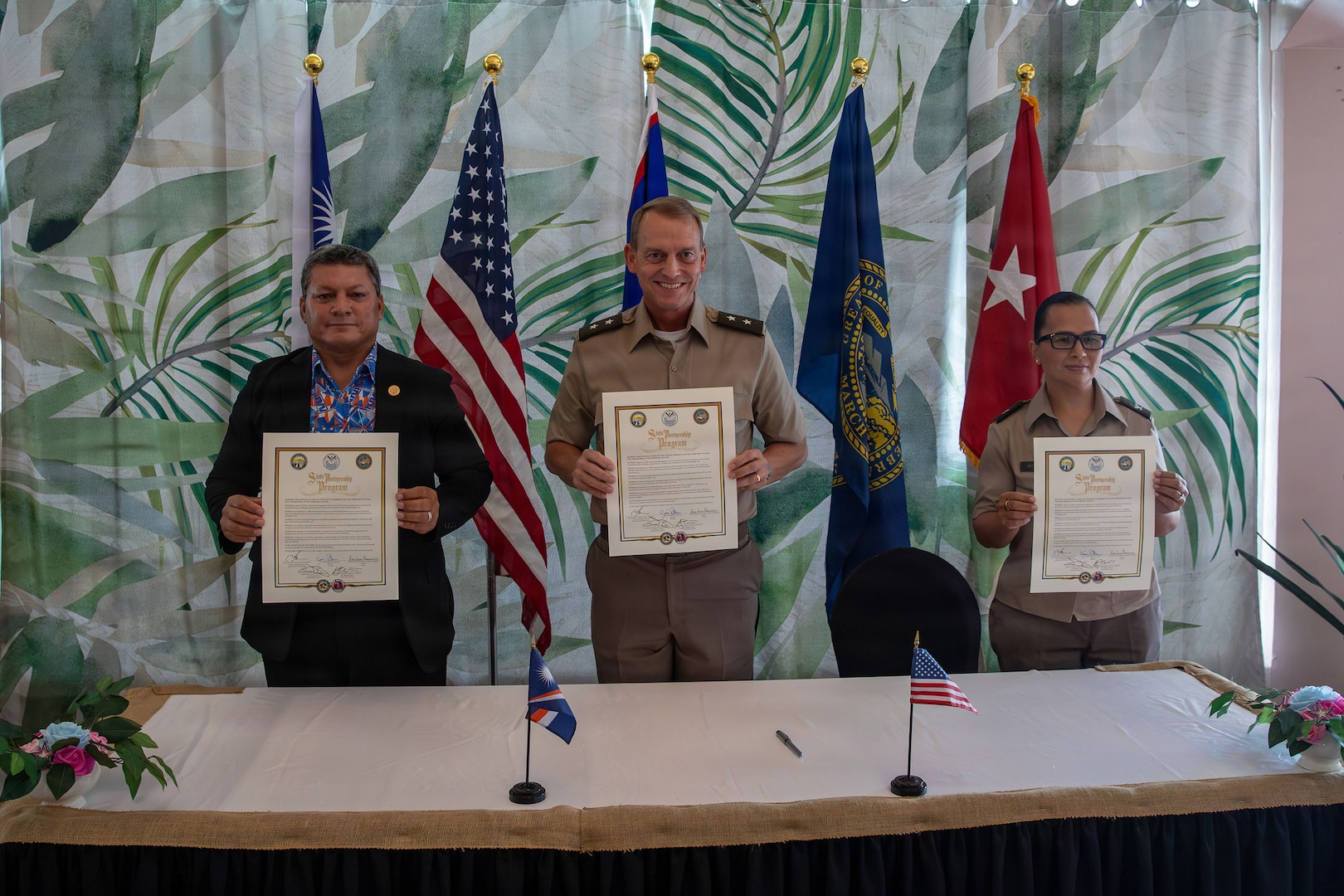 From left, Chris Debrum, director of the Republic of the Marshall Islands Office of National Security; Maj. Gen. Craig Strong, adjutant general of the Nebraska National Guard; and Brig. Gen. Karin Watson, adjutant general of the Guam National Guard, display the newly signed Department of War National Guard Bureau State Partnership Program agreements in Majuro, Republic of the Marshall Islands, Aug. 25, 2026.