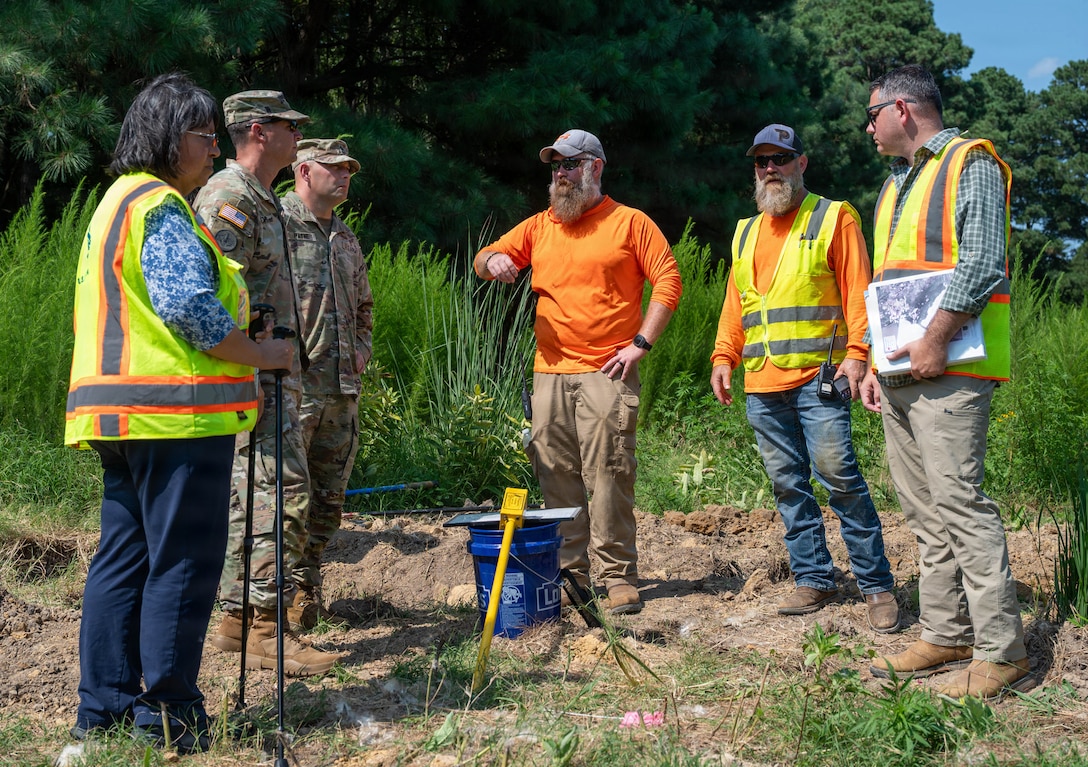 A group of people stand and talk together.