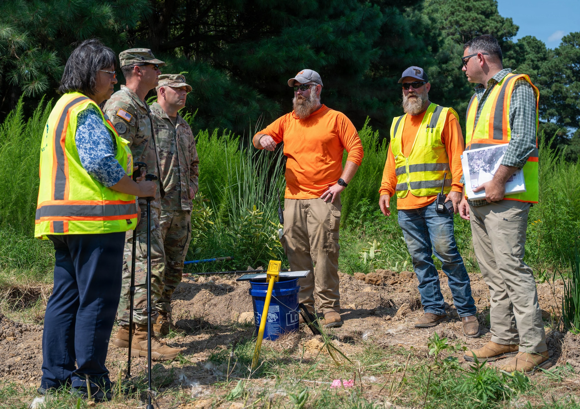 A group of people stand and talk together.