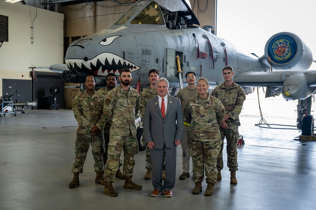 Congressman poses with Airmen assigned to the 23d Maintenance Group in front of an A-10C Thunderbolt II