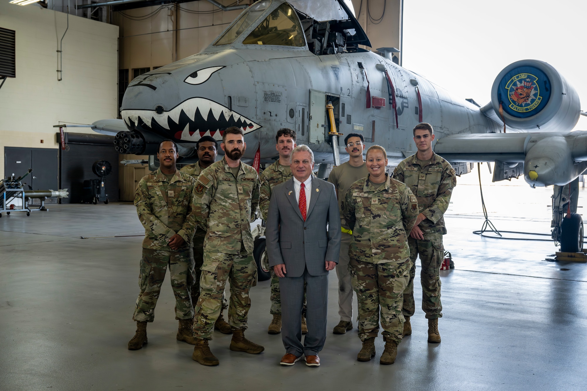 Congressman poses with Airmen assigned to the 23d Maintenance Group in front of an A-10C Thunderbolt II
