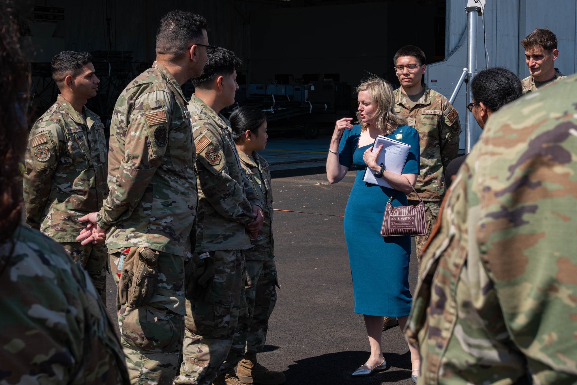 A woman speaks to a group of servicemembers