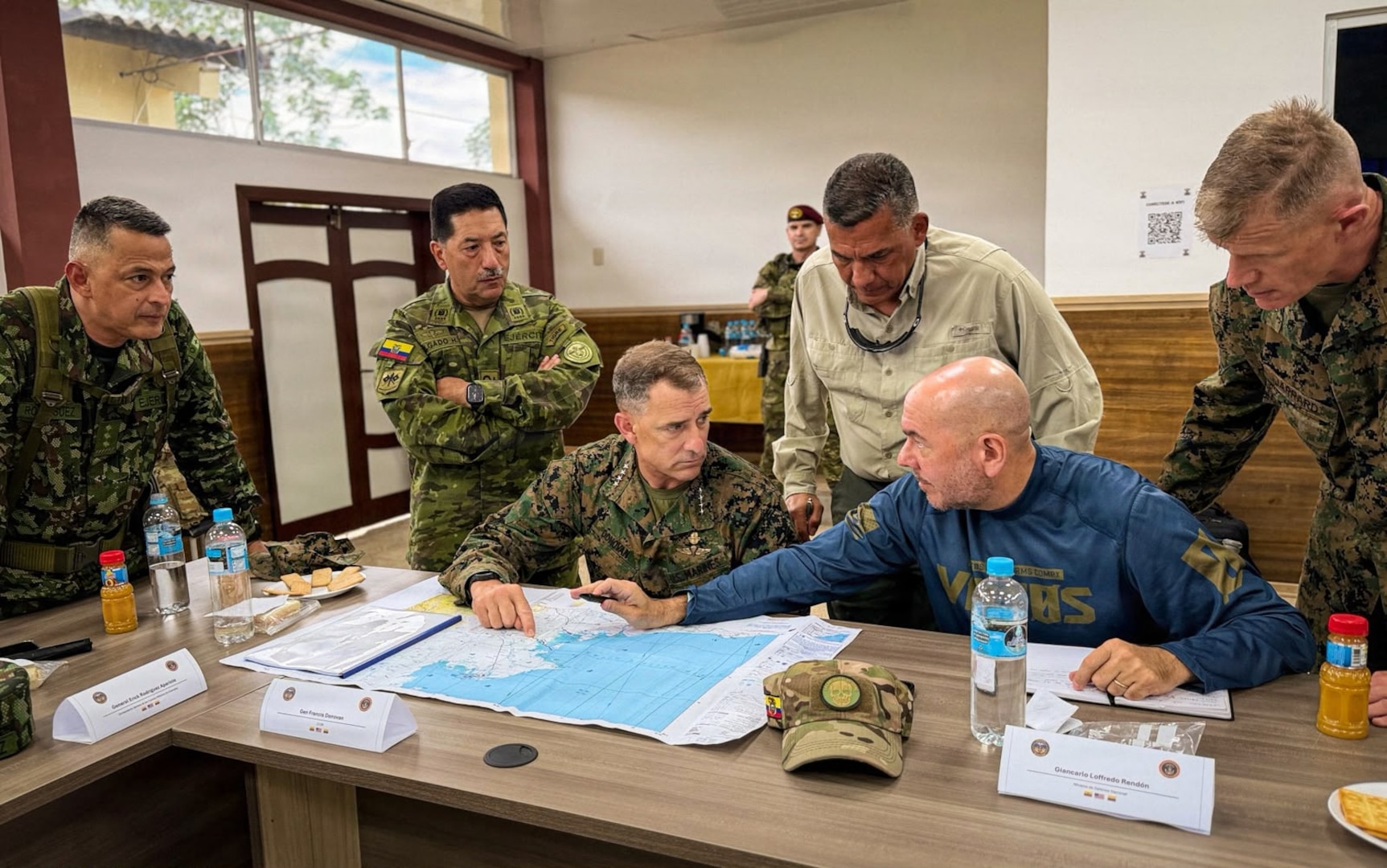 U.S., Ecuador, and Colombian senior leaders gather around a table and look at a map of the border of Colombia and Ecuador.