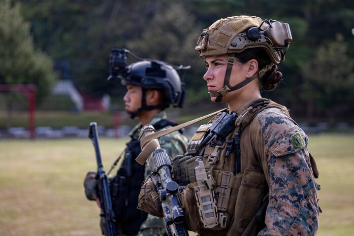 U.S. Marine Corps 1st Lt. Abigail Gutierrez, a platoon commander with Alpha Company, 1st Battalion, 5th Marine Regiment, Marine Rotational Force – Darwin 26, and an Indonesian marine corps platoon commander with 7th Infantry Battalion, 4th Brigade, stand at attention during a closing ceremony as part of a platoon exchange at the Indonesian Marine Corps 7th Infantry Battalion base near Lampung, Indonesia, Aug. 28, 2026.