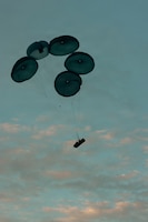 A Humvee descends beneath a parachute during an aerial resupply drop as part of exercise Saber Junction 26 at the Joint Multinational Readiness Center's Hohenfels Training Area, Germany, Aug. 24, 2026. The 7th Army Training Command provides a unique environment in Europe to develop leaders and formations prepared for large-scale combat operations, improving readiness. (U.S. Army photo by Spc. Aubrey Boyle, JMRC Vipers)