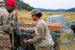 A U.S. Soldier assigned to the 173rd Airborne Brigade inspects an aerial delivery bundle following an airborne resupply mission during exercise Saber Junction 26 at the Joint Multinational Readiness Center (JMRC) Hohenfels Training area, Germany, Aug. 25, 2026. JMRC combat training center rotations drive unrivaled innovation and readiness in the U.S. Army Europe and Africa area of operations. (U.S. Army photo by Pfc. Jose Maria Martinez Magallanes)