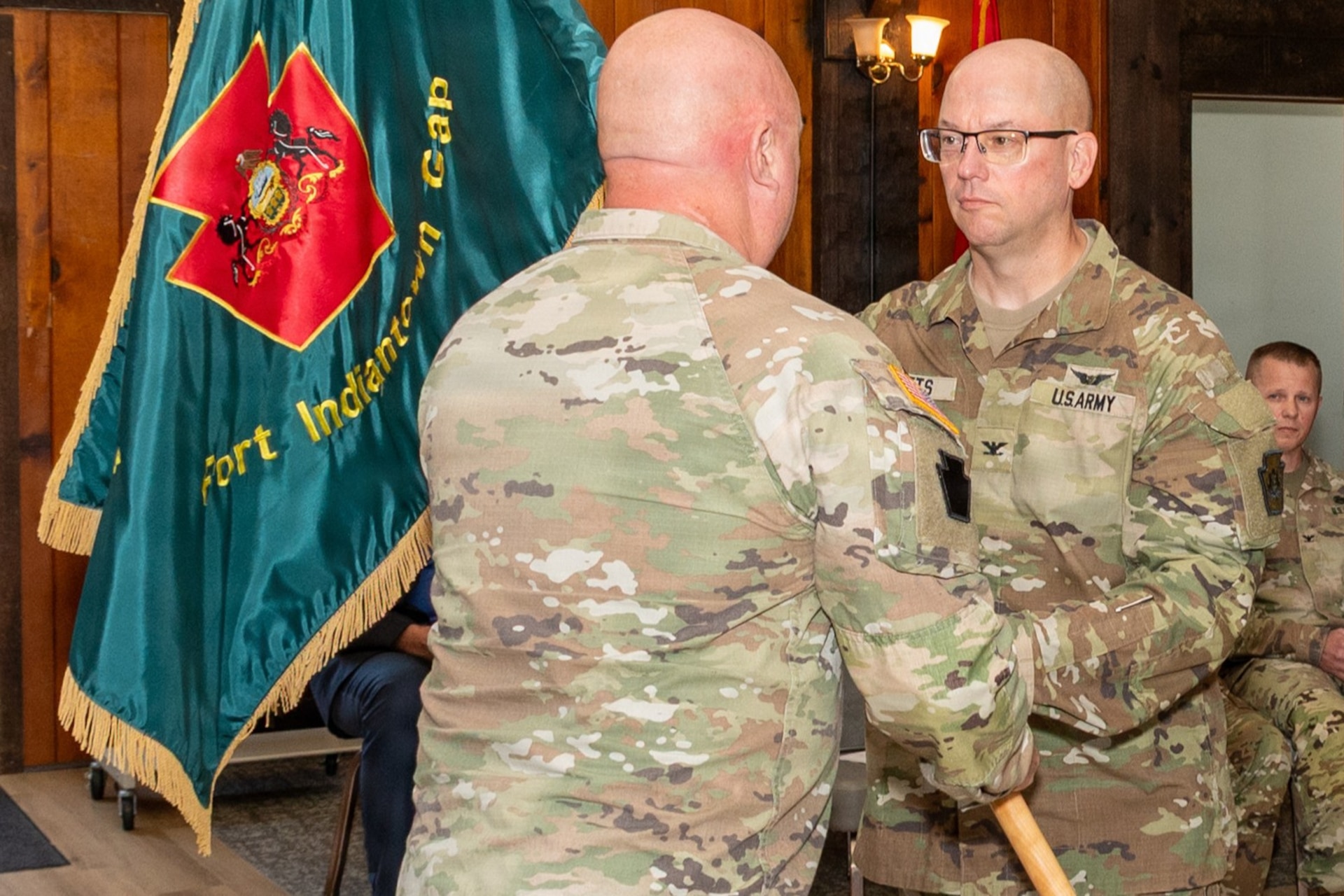 U.S. Army Maj. Gen. Michael E. Wegscheider, Pennsylvania National Guard Deputy Adjutant General-Army, passes the organizational colors to U.S. Army National Guard Lt. Col. Robert M. Cuthie during a change-of-command ceremony at Fort Indiantown Gap, Pennsylvania, Aug. 29. Cuthie assumed command of the Fort Indiantown Gap National Guard Training Center from U.S. Army National Guard Col. Kevin D. Potts during the ceremony. (Pennsylvania National Guard photo by Wayne V. Hall)