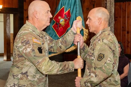 U.S. Army Maj. Gen. Michael E. Wegscheider, Pennsylvania National Guard Deputy Adjutant General-Army, passes the organizational colors to U.S. Army National Guard Lt. Col. Robert M. Cuthie during a change-of-command ceremony at Fort Indiantown Gap, Pennsylvania, Aug. 29. Cuthie assumed command of the Fort Indiantown Gap National Guard Training Center from U.S. Army National Guard Col. Kevin D. Potts during the ceremony. (Pennsylvania National Guard photo by Wayne V. Hall)