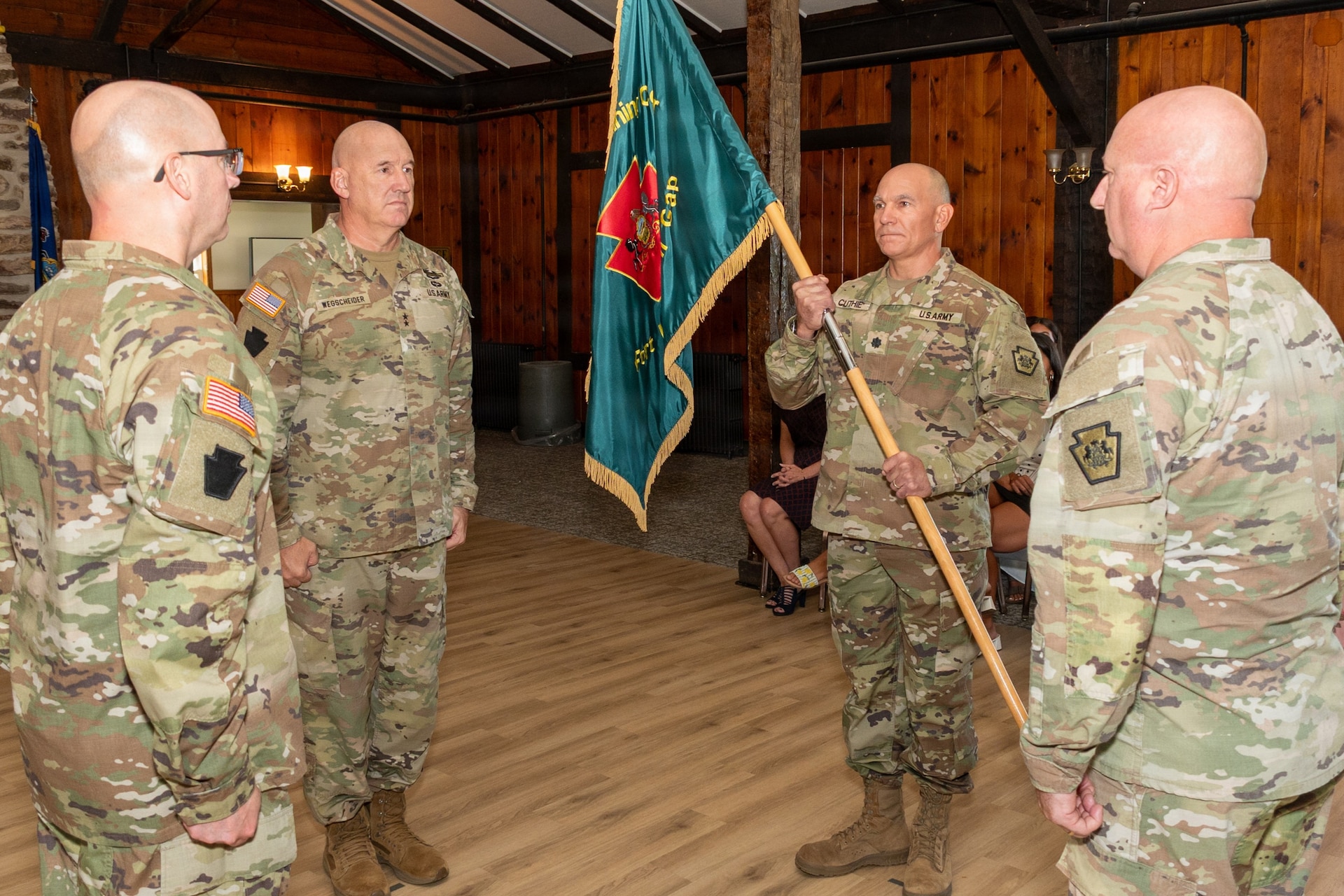 U.S. Army Maj. Gen. Michael E. Wegscheider, Pennsylvania National Guard Deputy Adjutant General-Army, passes the organizational colors to U.S. Army National Guard Lt. Col. Robert M. Cuthie during a change-of-command ceremony at Fort Indiantown Gap, Pennsylvania, Aug. 29. Cuthie assumed command of the Fort Indiantown Gap National Guard Training Center from U.S. Army National Guard Col. Kevin D. Potts during the ceremony. (Pennsylvania National Guard photo by Wayne V. Hall)