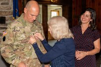 Family members pin the rank insignia of colonel onto Col. Robert M. Cuthie during a promotion ceremony at Fort Indiantown Gap, Pennsylvania, Aug. 29. The promotion ceremony was held immediately following a change-of-command ceremony where Cuthie assumed command of the Fort Indiantown Gap National Guard Training Center.