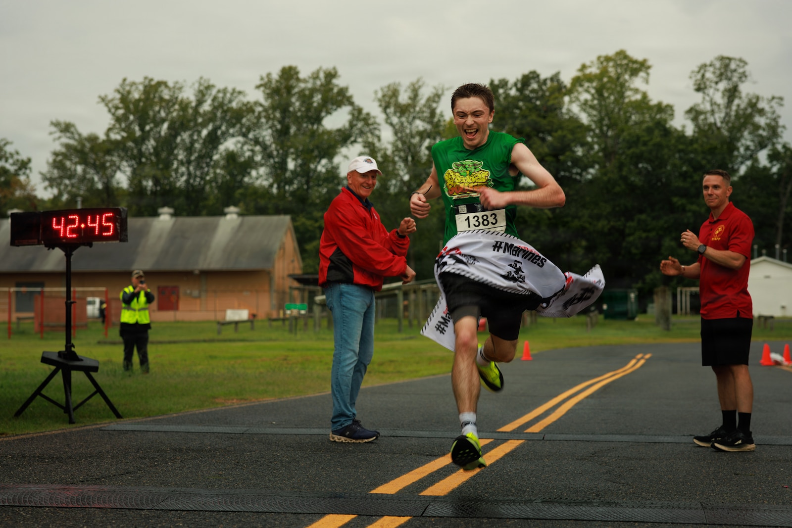 George Nix, the first-place finisher of the Quantico 12k, crosses the finish line during the race at Officer Candidates School on Marine Corps Base Quantico, Virginia, Aug., 22, 2026. The annual event challenged runners’ individual tenacity as they ran 7.46 miles of trails through the woods of OCS. (U.S. Marine Corps photo by Cpl. Harleigh Faulk)