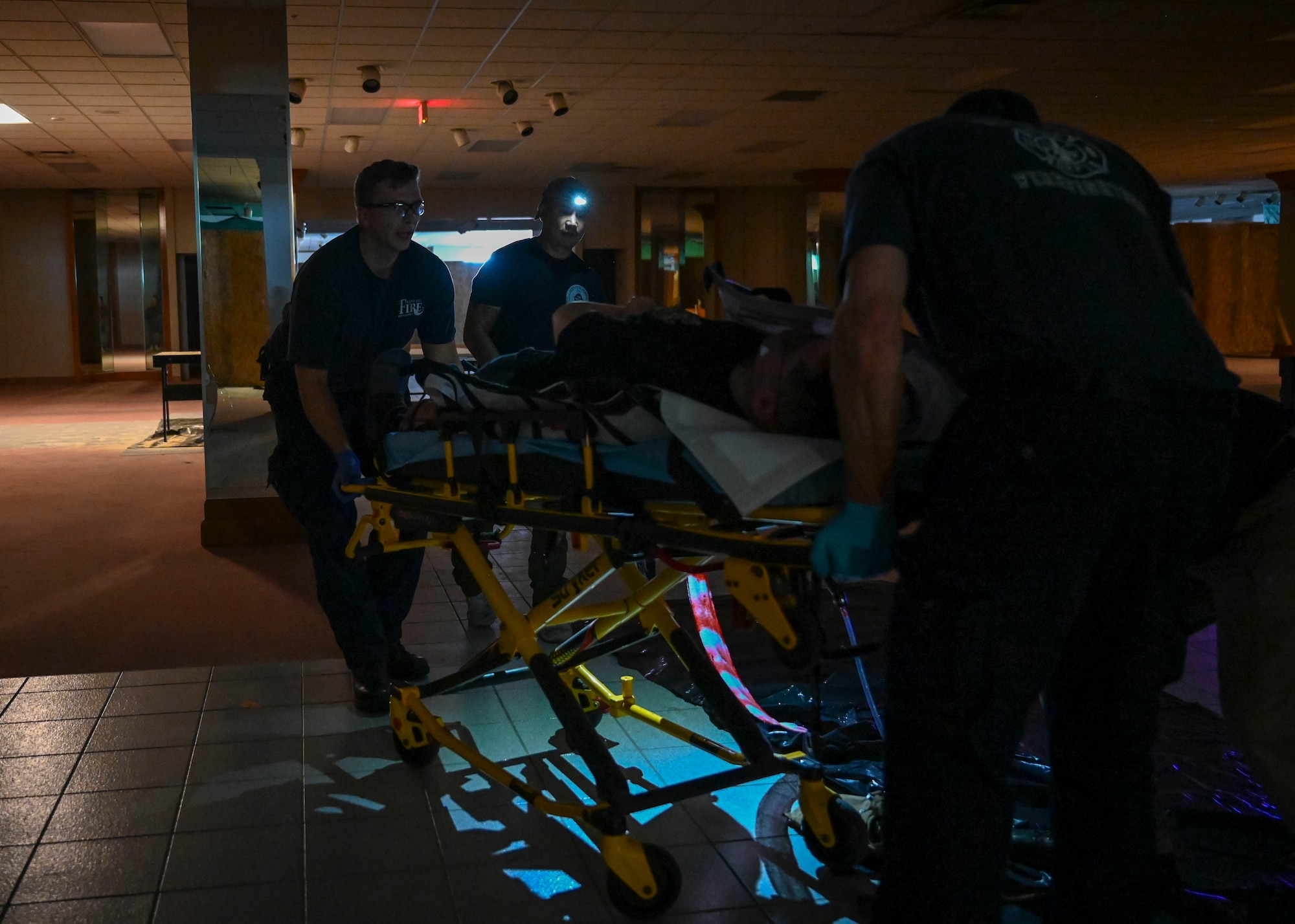 Two paramedics push a patient on a gurney.