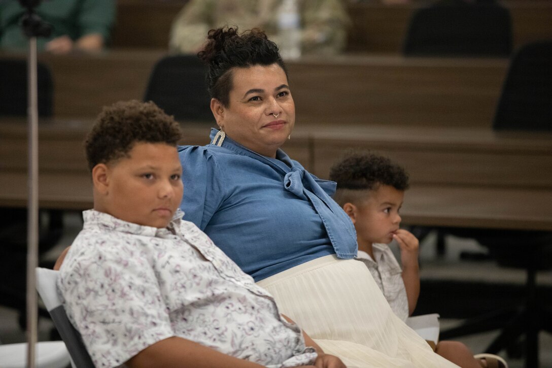 U.S. Army Sgt. Maj. Michael Meredith's wife, Maritza, and two sons, Brayden and Jameson, look on as he is promoted during a ceremony at Barker Auditorium at Boone National Guard Center in Frankfort, Kentucky, Aug. 10.