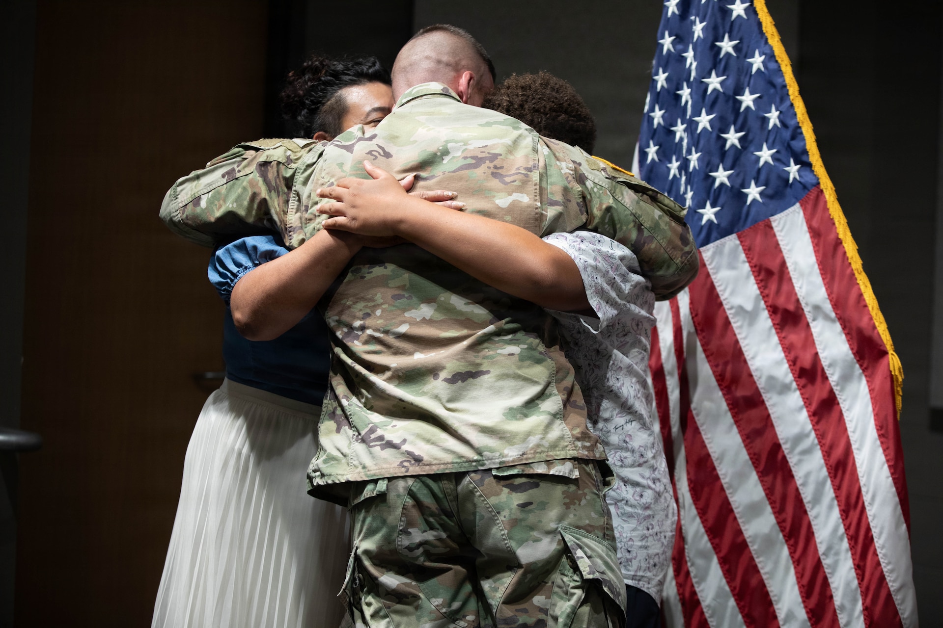 U.S. Army Sgt. Maj. Michael Meredith hugs his family during a promotion ceremony at the Barker Auditorium at Boone National Guard Center in Frankfort, Kentucky, Aug. 10.