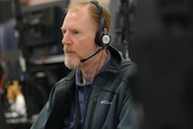 Civilian wearing a headset while working on a computer