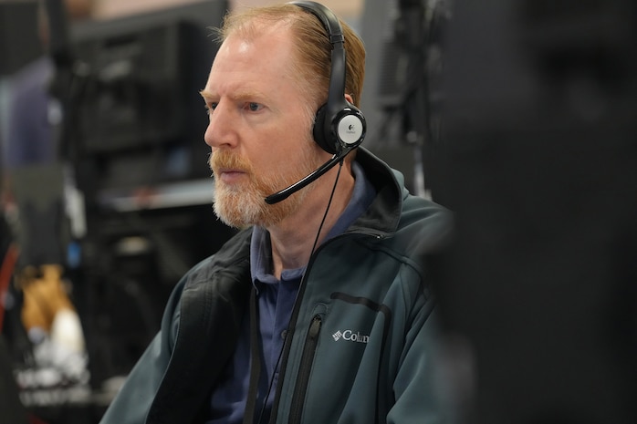 Civilian wearing a headset while working on a computer