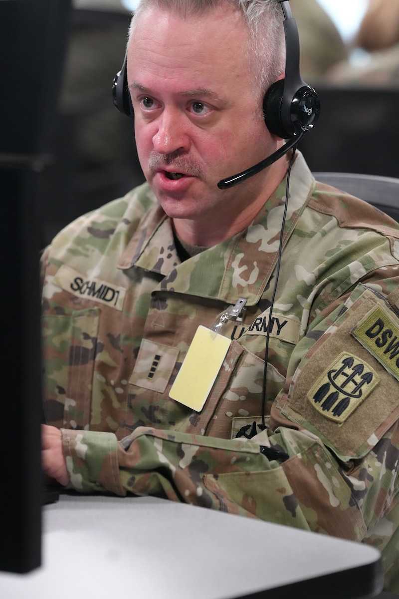 U.S. Soldier wearing a headset while working on a computer.