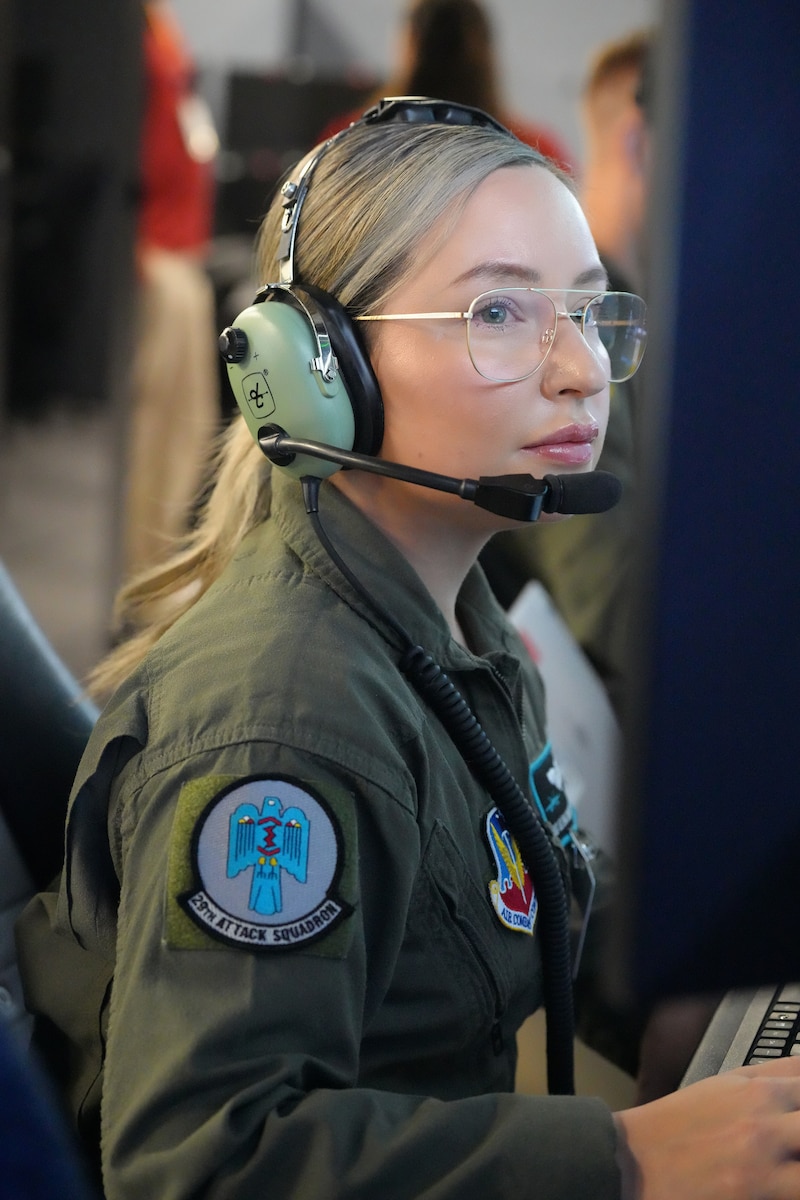 uniformed USAF Airmen fly MQ-9 simulators