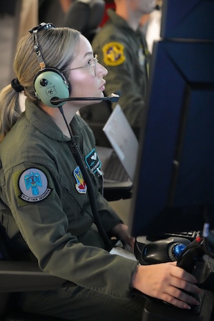 uniformed USAF Airmen fly MQ-9 simulators
