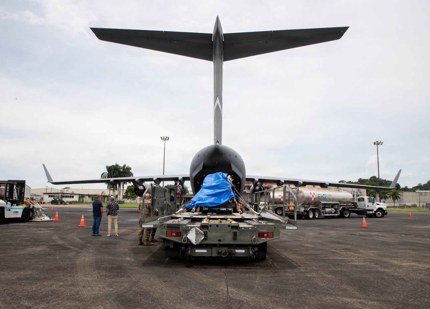 U.S. service members and Panamanians prepare to load machinery into a C-17 Globemaster III