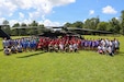 Kentucky National Guard senior leaders join campers for a group photo in front of a UH-60 Black Hawk helicopter during the annual Kentucky National Guard Youth Camp at Camp Loucon in Leitchfield, Kentucky, July 16, 2026. The annual camp brings children from Guard families together to build friendships, confidence and resilience while strengthening connections within the Guard community. (U.S. Army National Guard photo by Sgt. 1st Class Benjamin Crane)