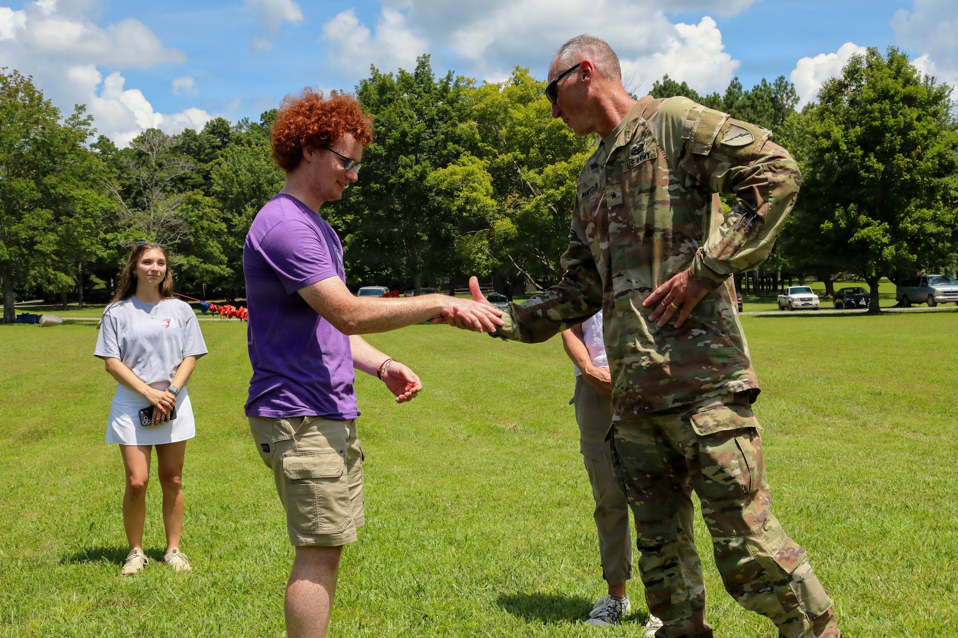 U.S. Army Brig. Gen. Brian Wertzler, deputy adjutant general for Kentucky, presents a challenge coin to Zach Van Meter, a Camp Loucon leader, in recognition of his support to the Kentucky National Guard Youth Camp at Camp Loucon in Leitchfield, Kentucky, July 16, 2026.