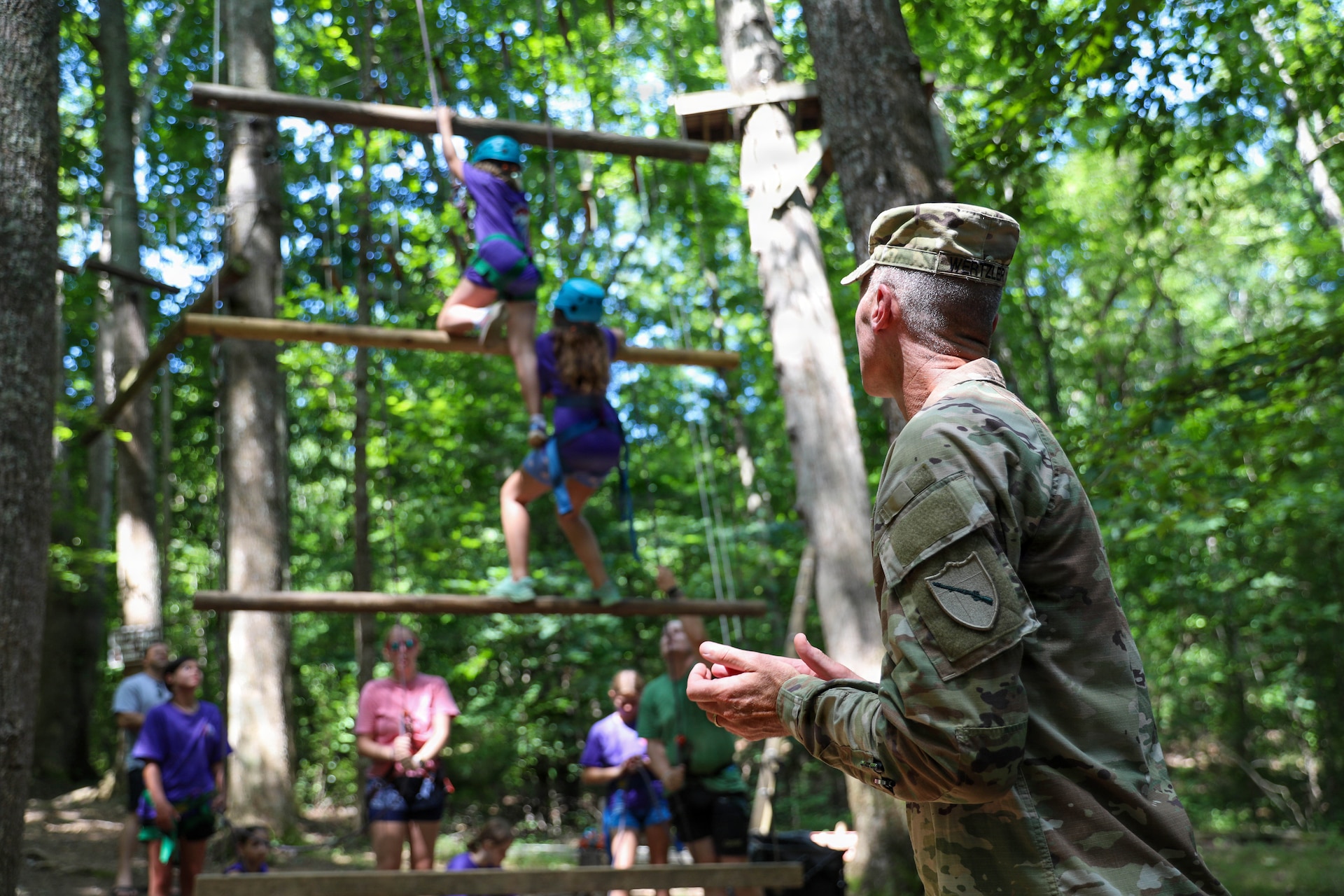 U.S. Army Brig. Gen. Brian Wertzler, deputy adjutant general of Kentucky, watches two campers take part in a team-building challenge during the Kentucky National Guard’s Youth Camp at Camp Loucon, in Leitchfield, Kentucky, July 16, 2026.