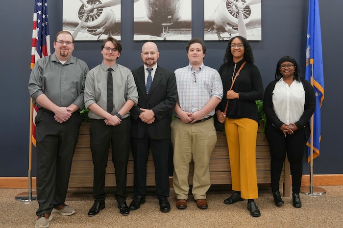 a group of six people pose together