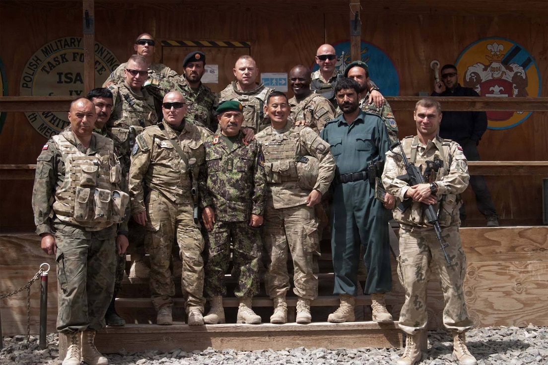 Illinois Army National Guard Soldiers who served alongside Polish Land Forces, Afghan National Army Soldiers, and other U.S. troops, pause for a group photo just days after Taliban insurgents attacked Forward Operating Base Ghazni, Afghanistan, Aug. 28, 2013.