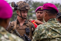 U.S. Marine Corps 1st Lt. William Copleston, a platoon commander with Alpha Company, 1st Battalion, 5th Marine Regiment, Marine Rotational Force – Darwin 26, receives a ceremonial brassard from Indonesian marines with 7th Infantry Battalion, 4th Infantry Brigade, during an opening ceremony for Exercise Super Garuda Shield 26 at the Indonesian Marine Corps 7th Infantry Battalion base near Lampung, Indonesia, Aug. 31, 2026.