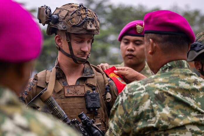 U.S. Marine Corps 1st Lt. William Copleston, a platoon commander with Alpha Company, 1st Battalion, 5th Marine Regiment, Marine Rotational Force – Darwin 26, receives a ceremonial brassard from Indonesian marines with 7th Infantry Battalion, 4th Infantry Brigade, during an opening ceremony for Exercise Super Garuda Shield 26 at the Indonesian Marine Corps 7th Infantry Battalion base near Lampung, Indonesia, Aug. 31, 2026.