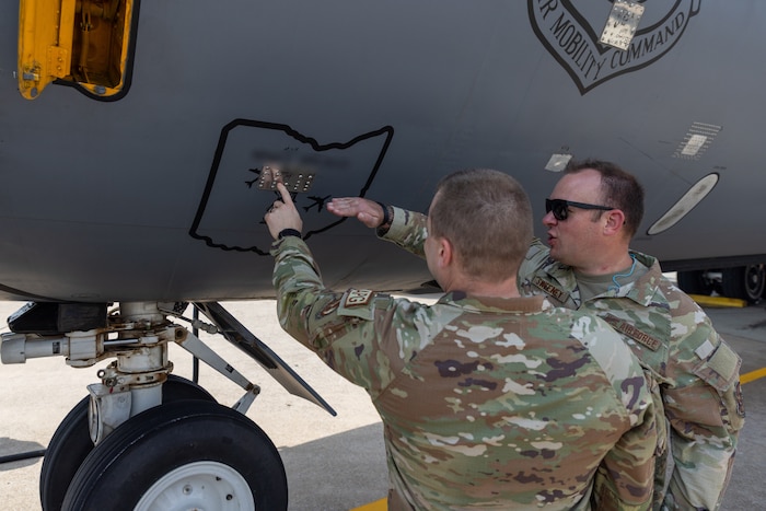 Two men pointing at patch on aircraft